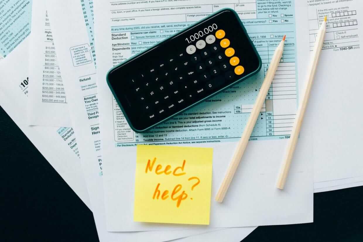 A calculator and a note of need help are present on the auditing sheet
