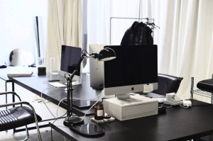 A Mac PC and a table lamp on a office table