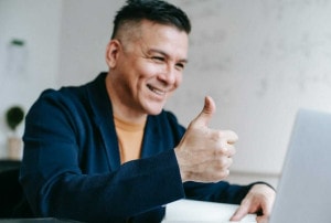 A person smiling while doing thumbs up
